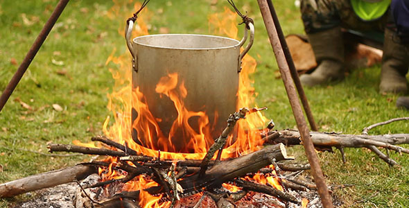 Cooking over a camp fire, with cast iron pots and coffee pot